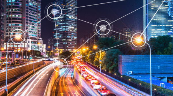 Carretera iluminada en ciudad inteligente con iconos de IoT conectados