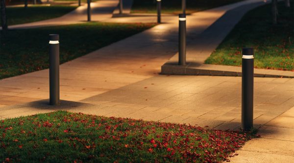 Row Of Outdoor Landscape Hard Paving Light. Lighting element on the green lawn along the footpath. Modern lighting system in landscape design